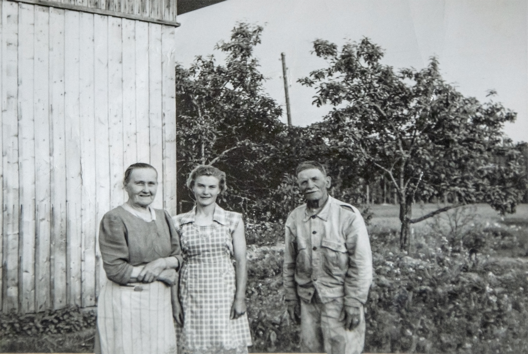 Fanny ja Santeri Kuusela, sekä tytär Hilkka. Takana Huvitus omenapuita.